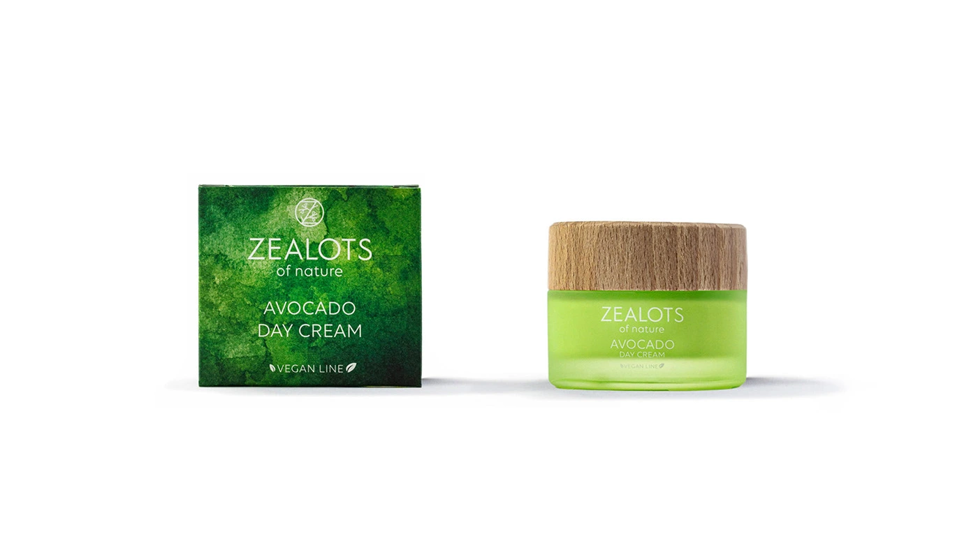 The Zealots of Nature avocado day cream: a green watercolor box next to a green glass jar with a wooden lid
